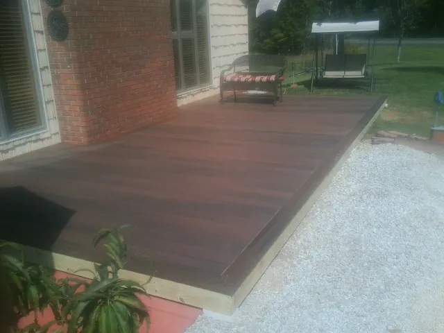 Freshly stained wood deck built against a brick home in Whiting
